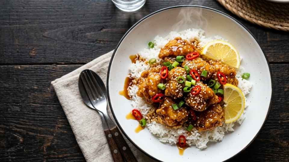 Ayam lemon madu crispy dengan saus kental mengkilap di atas nasi putih